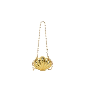 Detailed view of mini metallic shell bag featuring reflective gold finish and ball chain