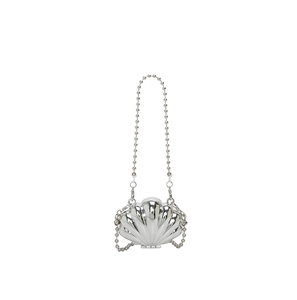 Detail of silver shell-shaped mini bag with metallic texture and sleek beaded chain