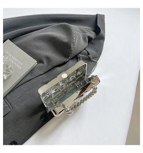 Internal view of silver wavy acrylic clutch with metallic handle and chain strap