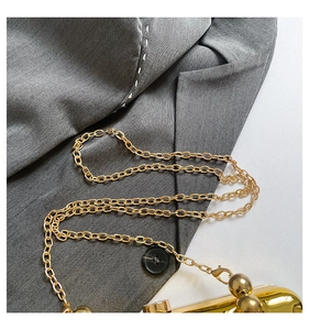 Detail of elegant gold metal chain strap with lobster clasp and wave pattern texture