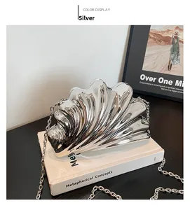 Detail of silver shell-shaped evening bag with mirror finish and detachable metal chain