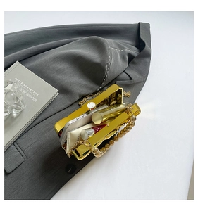 Golden acrylic wavy dinner clutch box bag showing storage for phone and lipstick