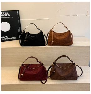 Detail of suede quilted handbags in four colors with elegant gold hardware