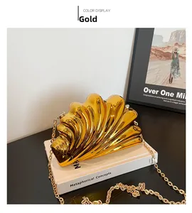 Detail of elegant gold shell evening bag with rippled texture and fine chain strap