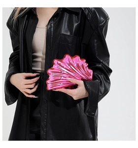 Detail of pink metallic shell-shaped crossbody bag with mirror finish and chain