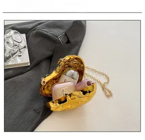 Macro view of heart-shaped gold evening bag interior showing cosmetic storage capacity