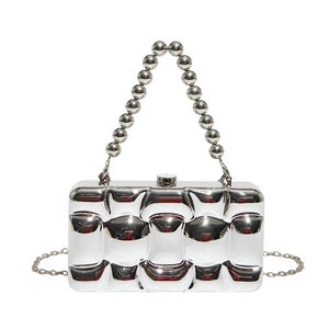 Detail of silver wavy quilted hard shell bag with large beaded handle and chain strap