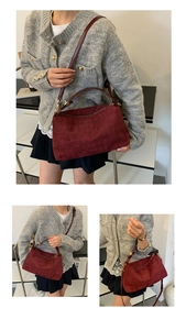 Macro view of burgundy suede tote with quilted texture and gold metal zipper details