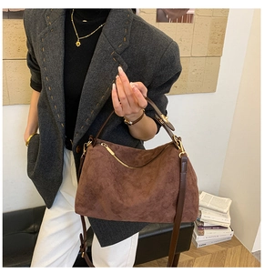 Detail of the vintage brown suede leather bag texture with shiny gold hardware accents