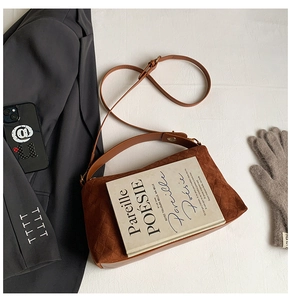 Detail of vintage brown suede tote bag with diamond quilted texture and leather shoulder strap
