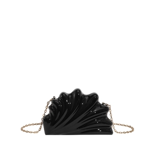 Detail of black shell-shaped acrylic evening bag with wave texture and gold chain