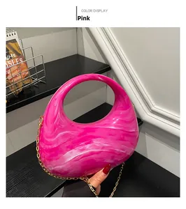 Detailed view of pink marble acrylic clutch bag with delicate gold shoulder chain