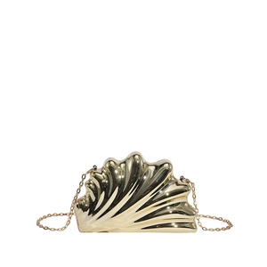 Macro detail of golden shell-shaped clutch featuring radial texture and fine metal chain