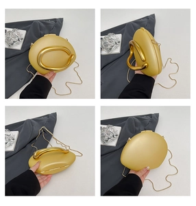 Detail view showing golden hard shell clutch with metal handle and detachable chain