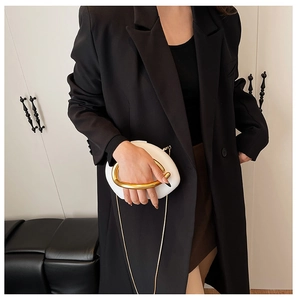 Chic white round clutch featuring a bold gold circular handle and delicate chain strap