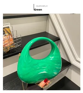 Close-up of green marble acrylic handbag with gold chain strap and curved handle