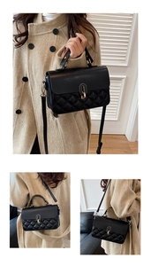 Macro shot of black quilted faux leather crossbody bag with golden oval lock clasp
