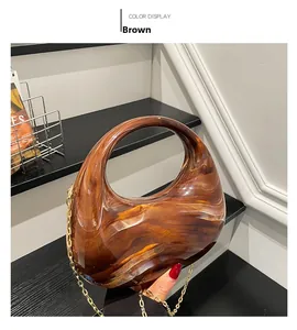 Detail of brown acrylic handbag with marble texture and elegant gold metal chain