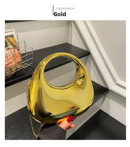 Detailed view of round gold mirror clutch bag with cutout handle and chain strap