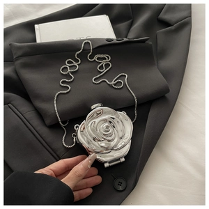 Macro shot of silver 3D rose-shaped acrylic evening bag with metallic finish on suit
