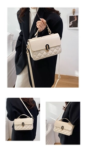 Close-up of cream quilted crossbody bag featuring elegant gold enamel twist lock detail
