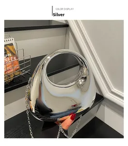 Polished silver pebble-shaped acrylic clutch bag with a sleek circular cutout handle