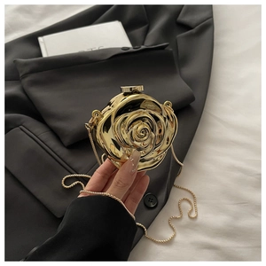 Detail of 3D rose flower clutch with gold metallic finish and fine chain strap