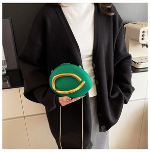 Bright green pebble-shaped clutch bag with large gold handle and elegant chain strap