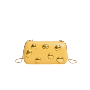 Detail of yellow rectangular PU clutch bag with polished gold pebble metal accents and chain