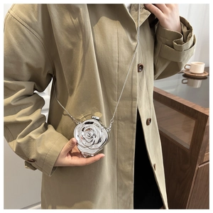 Detailed close-up of a silver rose flower mini clutch bag with metallic mirror finish