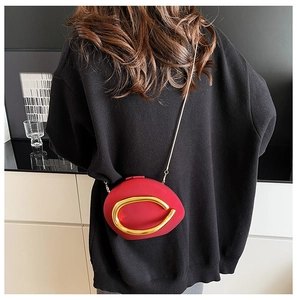 Red asymmetric round evening bag with large gold C-handle and fine chain strap detail
