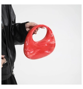 Chic red marble acrylic handbag with unique circular hollow design held by model