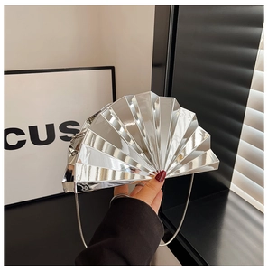 Detailed view of silver fan-shaped clutch with metallic finish and delicate chain strap