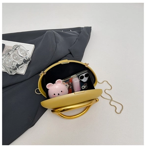 Open view of a round yellow hardshell evening bag showing phone and lipstick storage