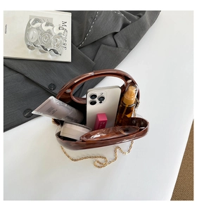 Detail of tortoise shell acrylic bag showing interior capacity for phone and cosmetics