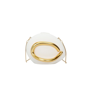 Detail of white pebble-shaped evening bag with bold gold curved metal accent and chain strap