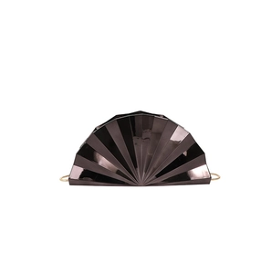 Detail of elegant black fan-shaped evening clutch bag with glossy finish and gold chain