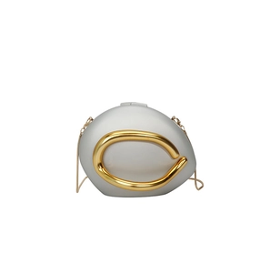 Close-up of pebble-shaped evening clutch bag with gold ring hardware and chain strap