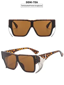 Détail de lunettes de soleil oversize écaille avec flammes argentées et verres thé