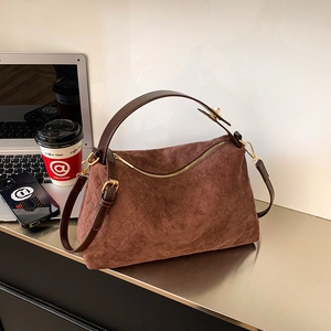 Brown suede diamond quilted handbag with diagonal zipper and adjustable shoulder strap