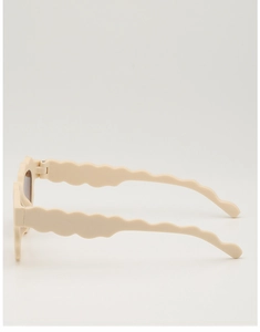 Detail view of beige retro children's sunglasses with unique scalloped wavy temples