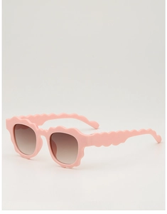 Detail view of pink wavy frame sunglasses with brown gradient lenses for kids