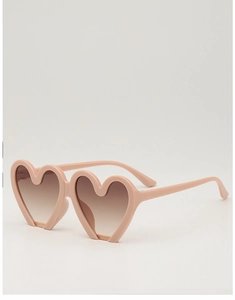 Detail view of heart-shaped sunglasses featuring peach matte frames and gradient lenses