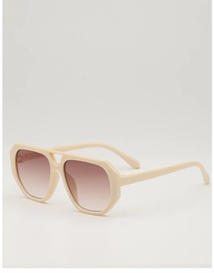 Detail view of retro cream pilot sunglasses with thick frames and gradient brown lenses