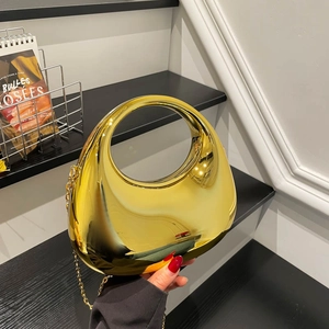 Golden mirrored crescent handbag with circular handle and detachable chain strap