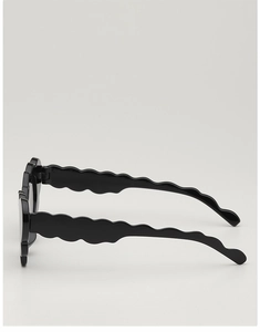 Close-up of black kids sunglasses featuring stylish scalloped wave design on the side temples