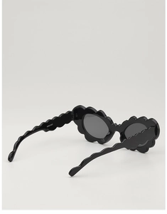 Close-up of black kids' sunglasses with scalloped wave frames and glossy temples