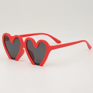 Kids trendy red heart shaped sunglasses with dark grey lenses in a 45-degree side view