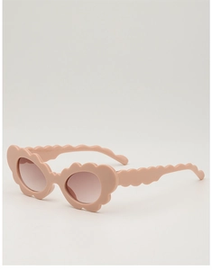 Close-up of pink wave-edge kids sunglasses with matte finish and gradient lenses