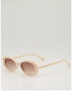 Close-up of cream retro oval children sunglasses with decorative hollow frame details